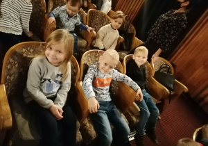 Dzieci siedzą na widowni teatru.